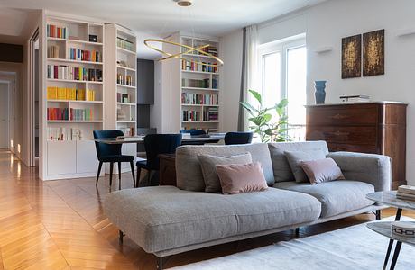 Modern living room with sofa, bookshelf, and dining area.