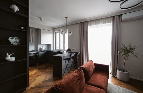 Modern open-plan kitchen and living area with minimalist decor and hardwood floors.