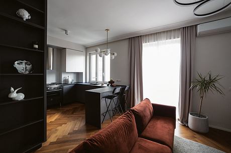 Modern open-plan kitchen and living area with minimalist decor and hardwood floors.