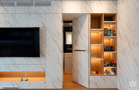 Sleek marble walls, built-in storage shelves, and recessed lighting create a modern, minimalist interior.