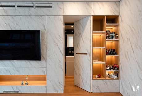 Sleek marble walls, built-in storage shelves, and recessed lighting create a modern, minimalist interior.