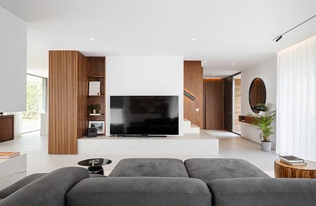 Modern living room with sleek furniture and wooden accents.