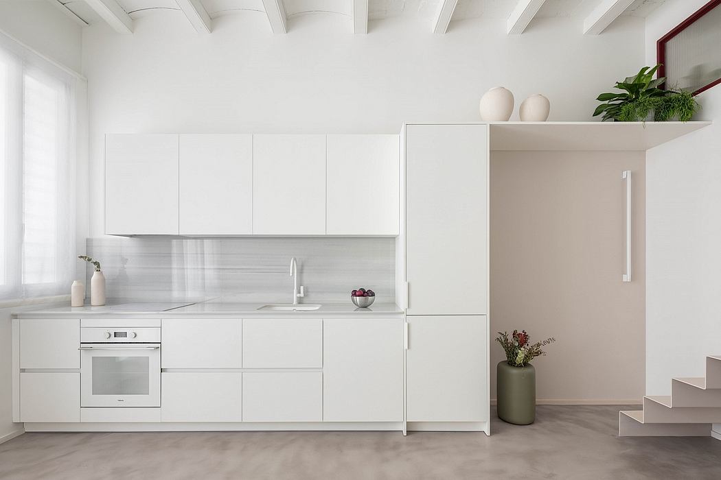 Minimalist white kitchen with clean lines and plants.