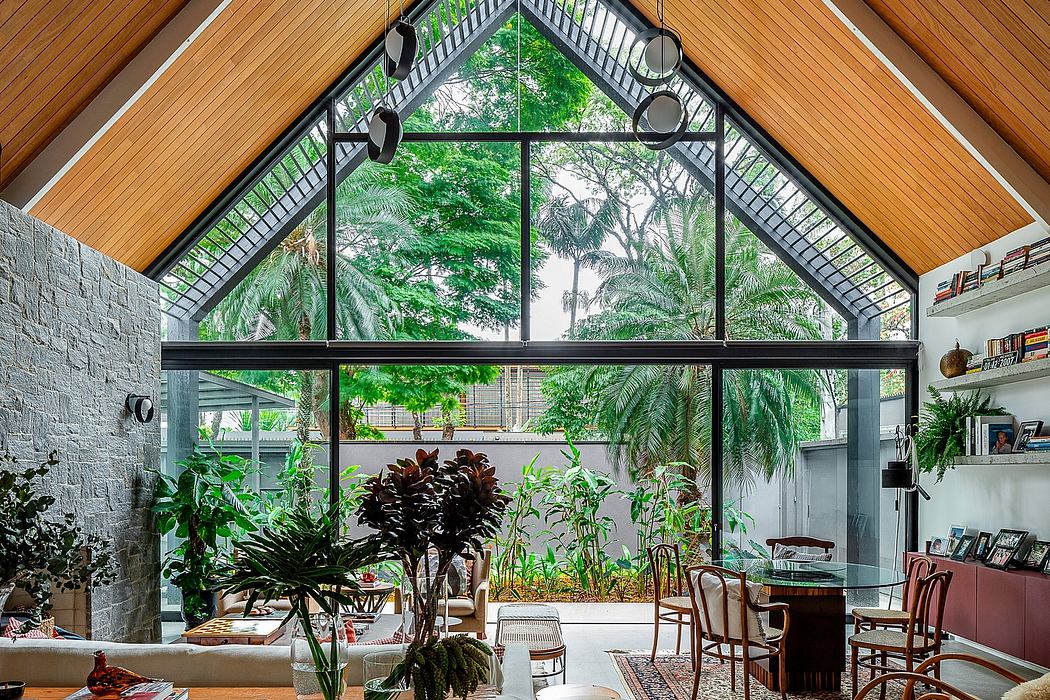 Airy room with high ceilings, exposed beams, large windows, and lush green