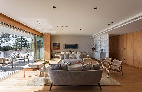 Contemporary living room with wooden finishes and large windows.