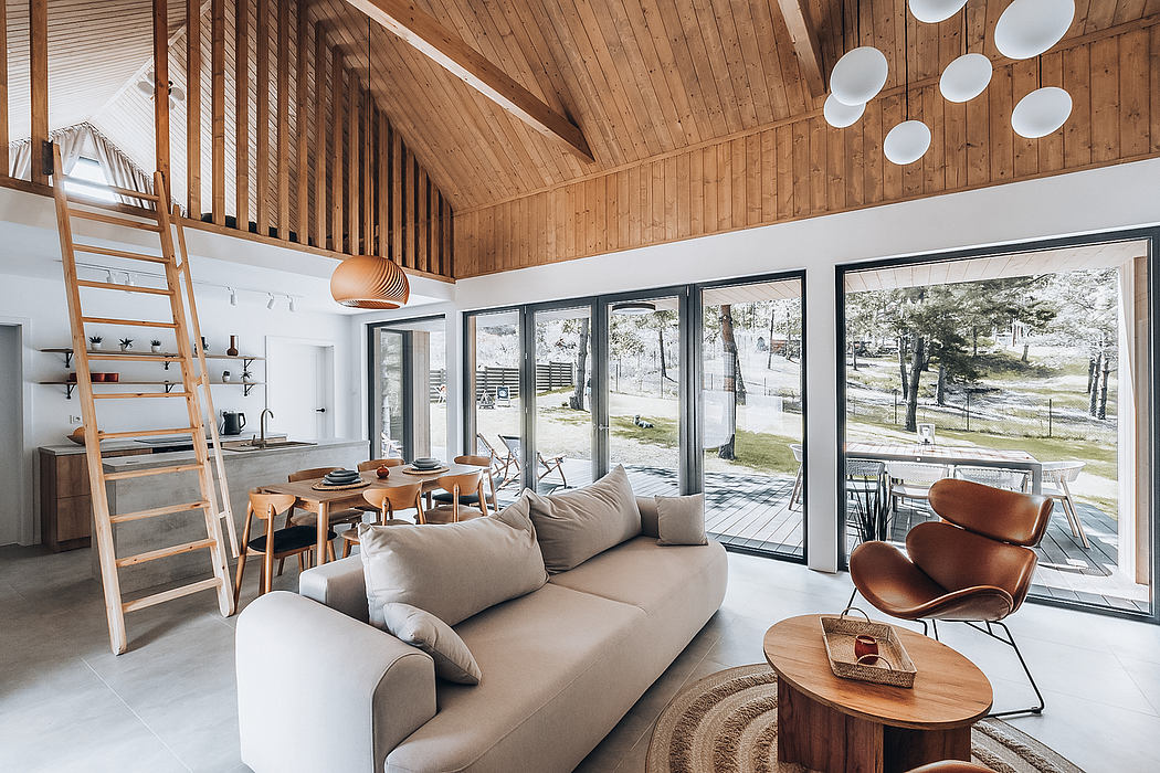 A cozy cabin interior with a vaulted wooden ceiling, large windows, and modern furniture.