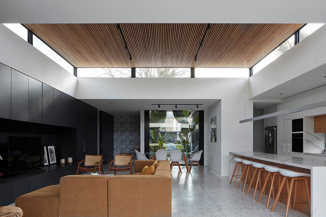 Contemporary living space with slatted wood ceiling and sleek kitchen.