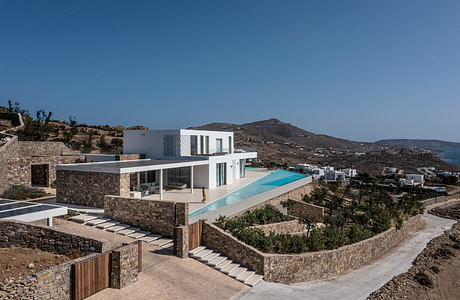 Modern hillside villa with a pool overlooking the sea.