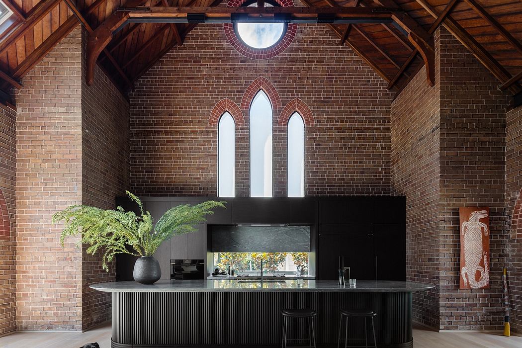 Stunning brick interior with arched windows, modern black kitchen island, and a small dog.
