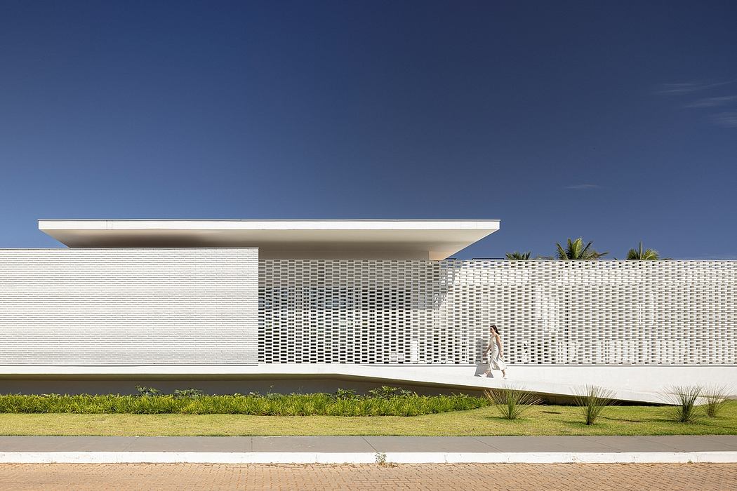 Minimalist exterior with clean lines, perforated facade, and lush landscaping.