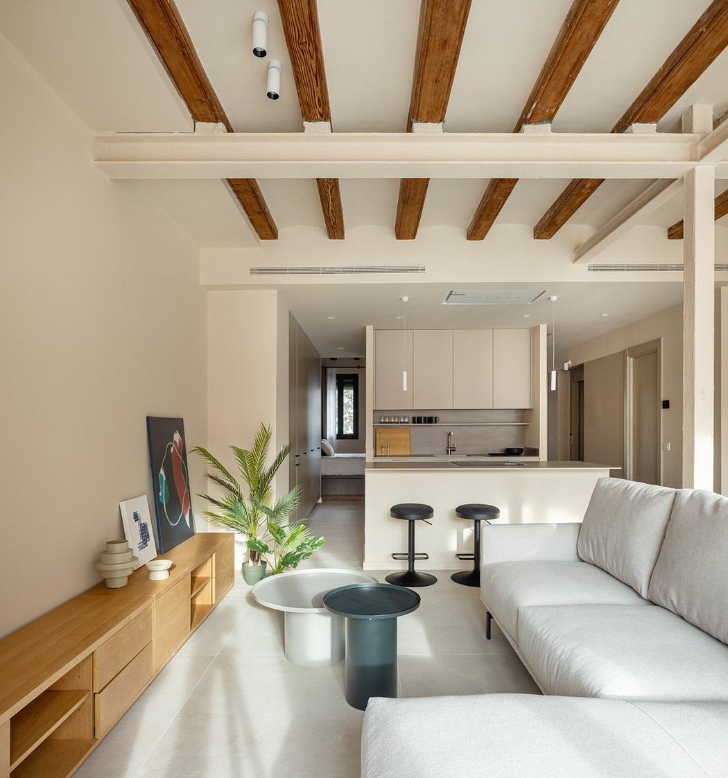 Neutral-toned contemporary living space with exposed wooden beams and modern furniture.
