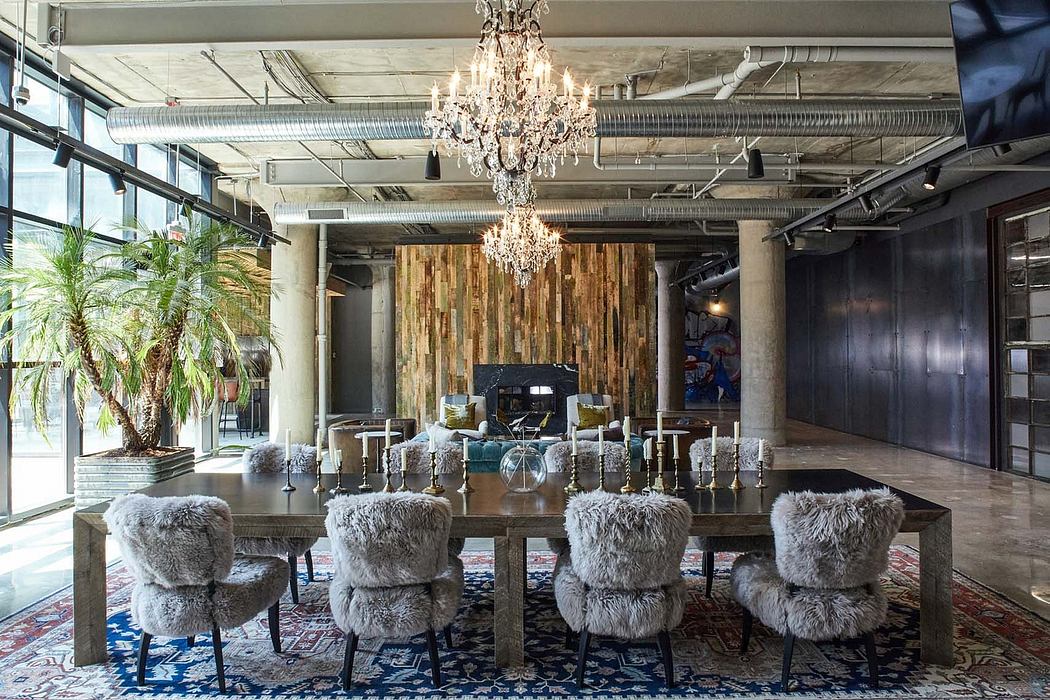 An eclectic, high-ceilinged space with a stunning crystal chandelier, rustic wood paneling, and plush fur-covered chairs.