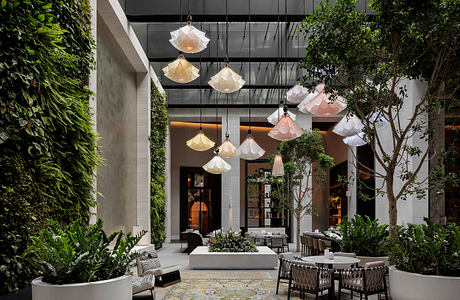 Elegant indoor garden with pendant lights, lush greenery, and contemporary furnishings.