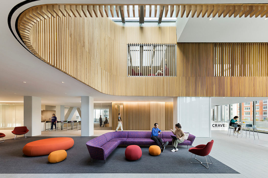 Striking wooden slat ceiling curves above vibrant color-blocked lounge seating.