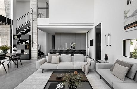 Sleek, minimalist living space with modern furniture, glass walls, and industrial accents.