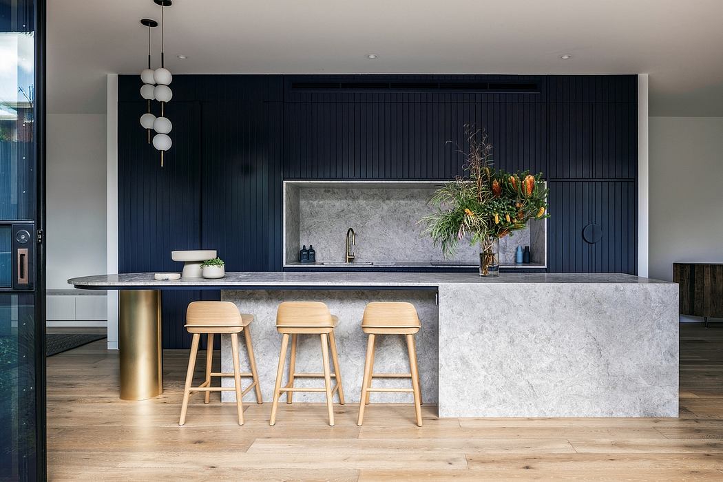 Sleek, modern kitchen with dark cabinets, stone countertops, and pendant lighting.