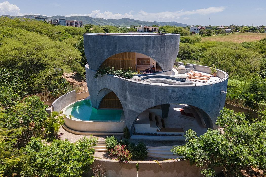 Circular concrete structure with wood accents, pool, and terraced exterior surroundings.