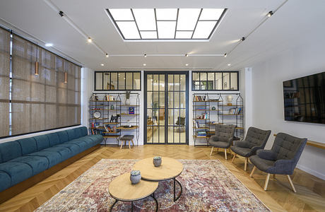 Bright, modern living space with textured curtains, custom shelves, and parquet flooring.