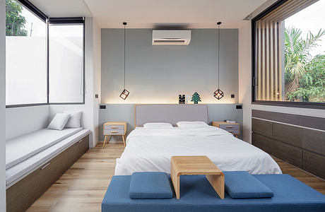 Modern minimalist bedroom with wood accents, neutral color palette, and nature views.