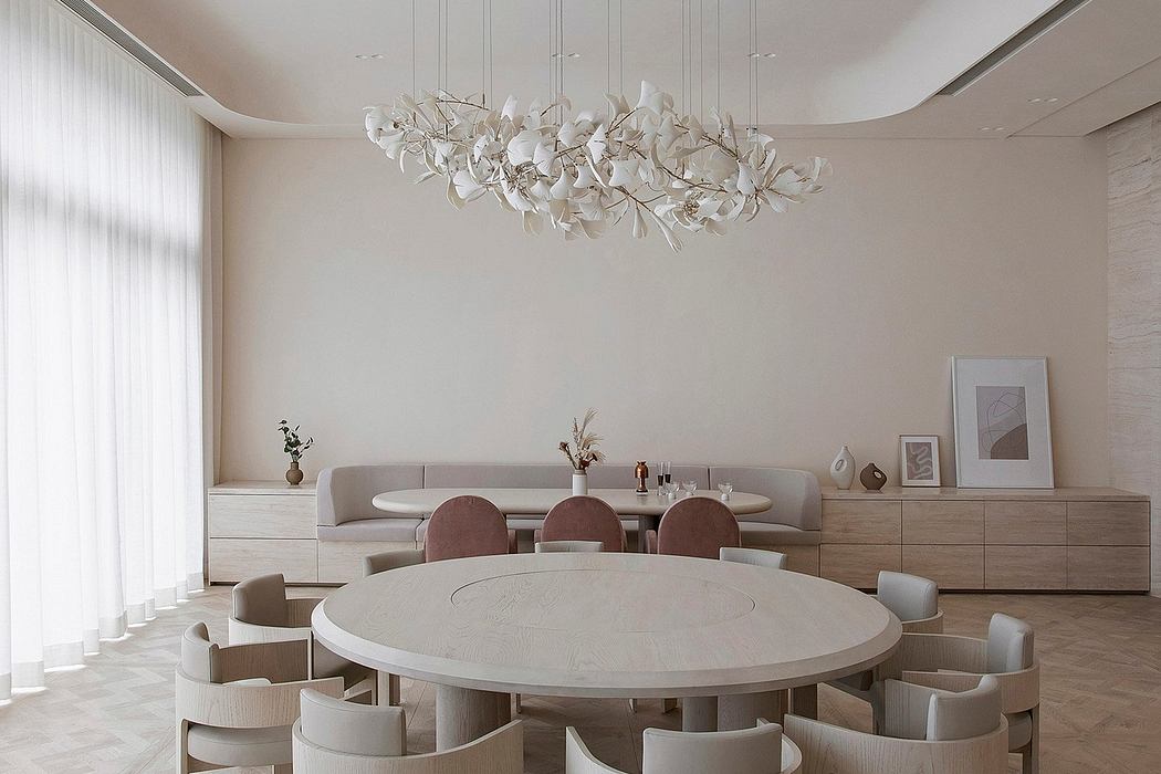 Minimalist dining room with a round table, beige chairs, and an artistic ch