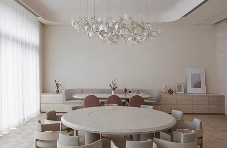 Minimalist dining room with a round table, beige chairs, and an artistic ch