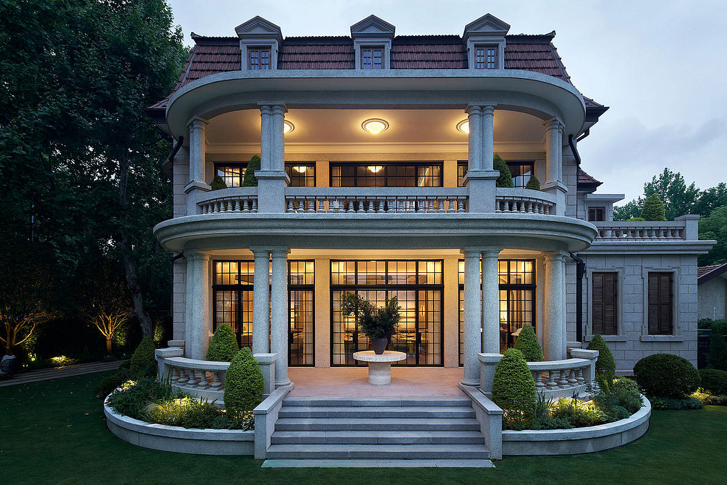 Elegant neoclassical mansion with ornamental columns, balconies, and a manicured garden.