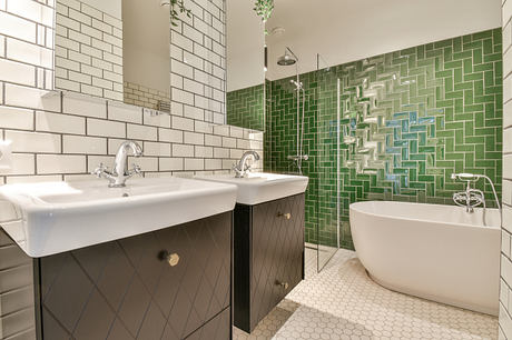 Contemporary bathroom with green tiled shower and freestanding tub.