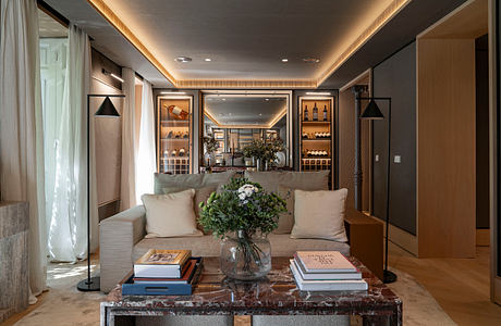 Luxurious living room with contemporary furniture, marble coffee table, and built-in shelves.