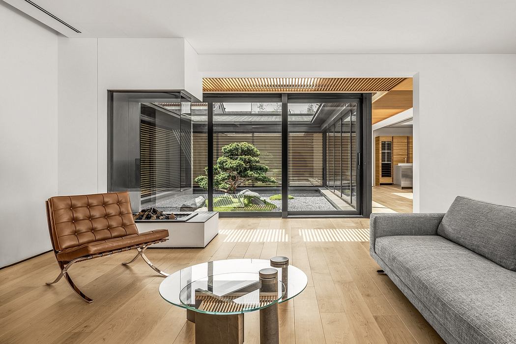 Elegant modern living space with glass walls, wooden accents, and a serene indoor garden.