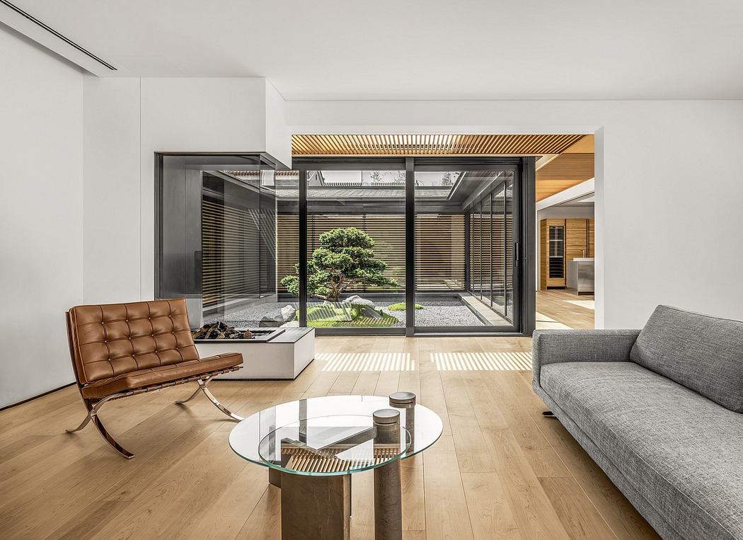 Elegant modern living space with glass walls, wooden accents, and a serene indoor garden.