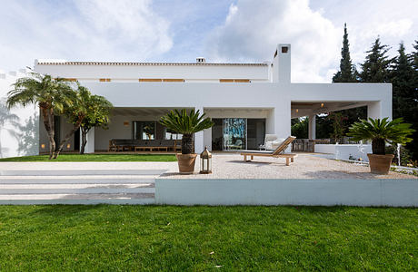 Striking modern villa with tropical landscaping, covered terrace, and sleek architectural design.