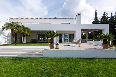 Striking modern villa with tropical landscaping, covered terrace, and sleek architectural design.