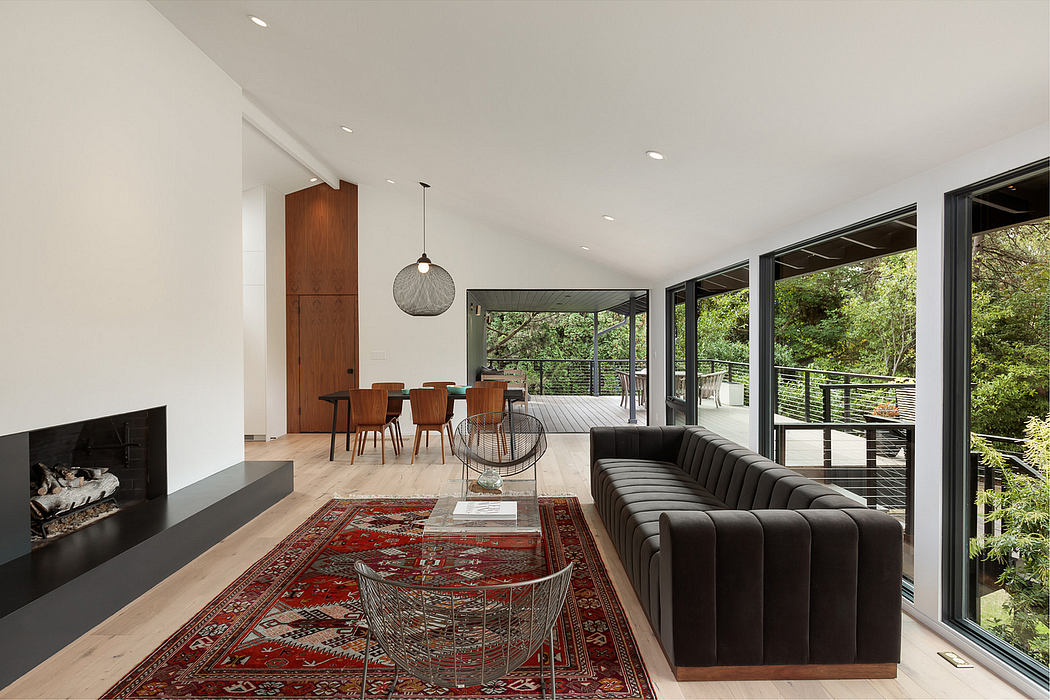 Expansive open-concept living area with modern furniture, neutral tones, and lush outdoor view.