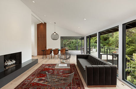 Expansive open-concept living area with modern furniture, neutral tones, and lush outdoor view.