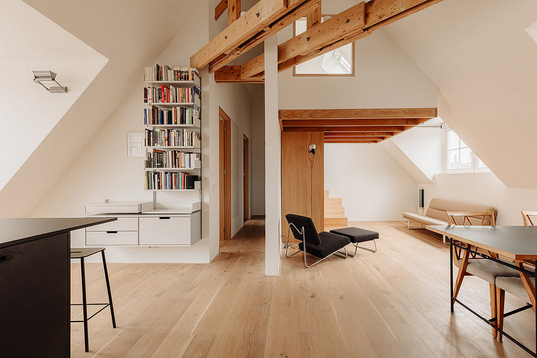 Airy, open-plan living space with natural wood beams, recessed shelving, and modern furnishings.
