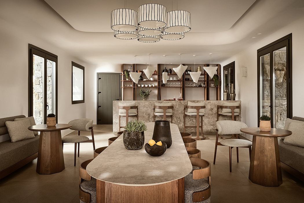 An elegant, modern dining area with a concrete dining table, plush seating, and a striking chandelier.