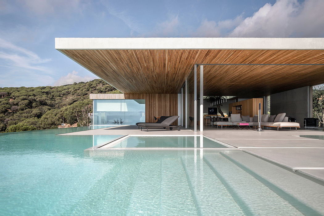 Sleek wooden pavilion with an infinity pool overlooking lush forest scenery.