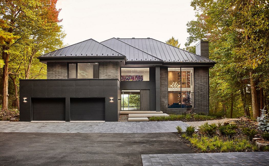 Contemporary brick and metal exterior with large windows and garage doors, surrounded by lush foliage.
