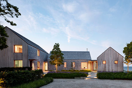 Modern wooden structures with roofs and windows, set in a lush, landscaped yard.