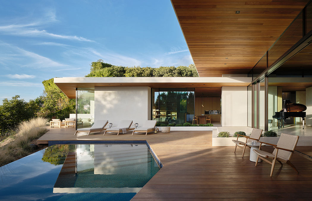 A modern home with an expansive deck, infinity pool, and sleek wooden interiors.
