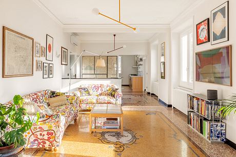 Spacious and eclectic living room featuring ornate tile flooring, vibrant artwork, and custom lighting.