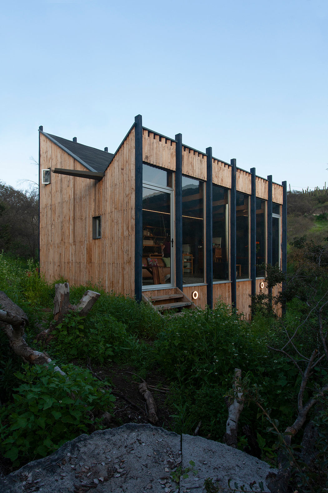 A modern, wood-paneled building with large windows overlooking a natural landscape.