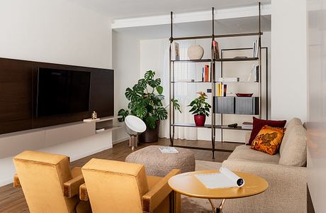 Stylish modern living room with sleek TV unit, shelving, and plush seating.