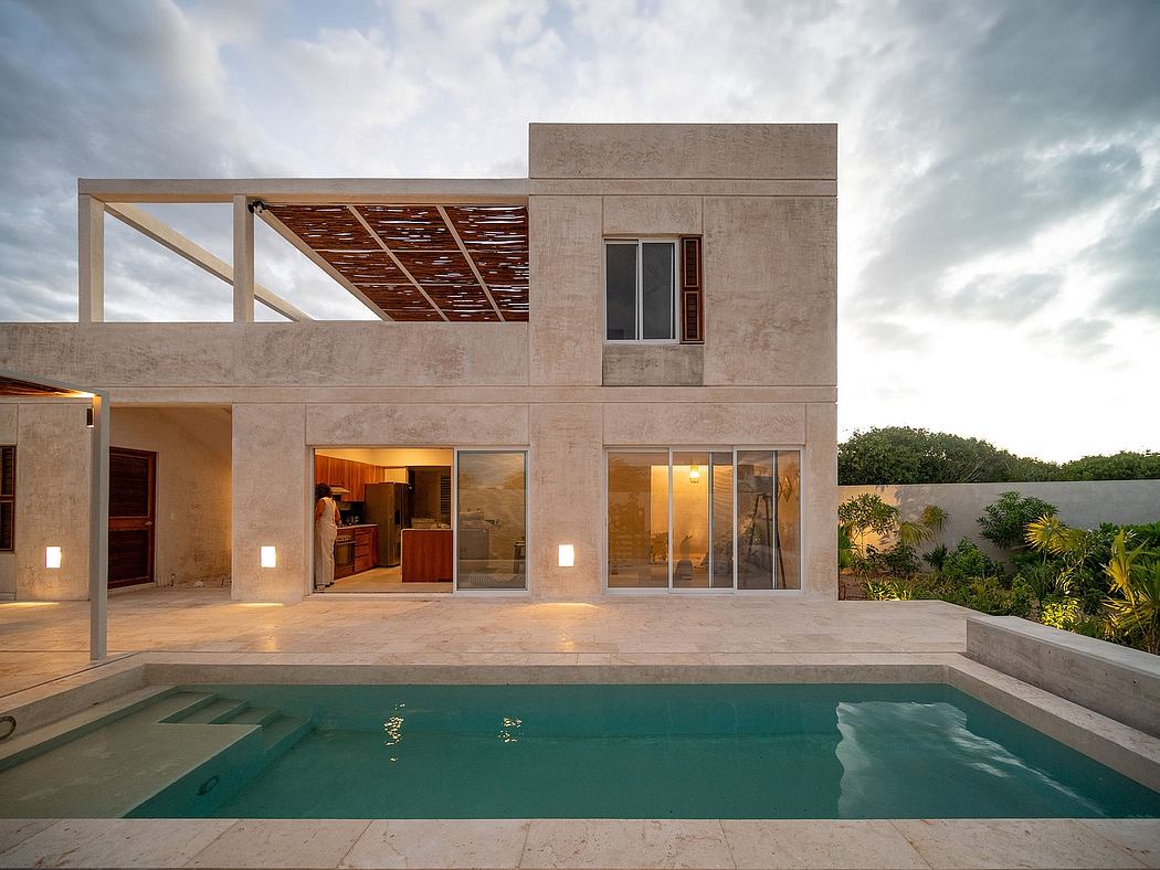 A modern, minimalist home with a sleek concrete exterior, large glass windows, and a private pool.