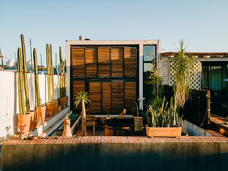 A cozy outdoor living space with wooden screens, potted plants, and a relaxing atmosphere.