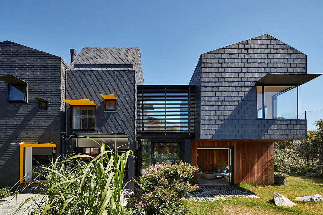 Striking contemporary architecture featuring bold black cladding, wood accents, and dynamic roof forms.