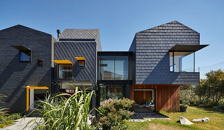 Striking contemporary architecture featuring bold black cladding, wood accents, and dynamic roof forms.