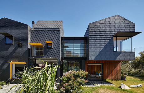 Striking contemporary architecture featuring bold black cladding, wood accents, and dynamic roof forms.