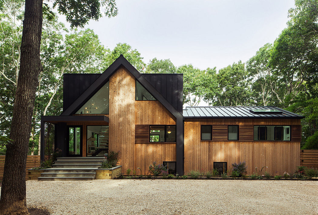 A modern, rustic cabin with a combination of wood, metal, and glass elements.