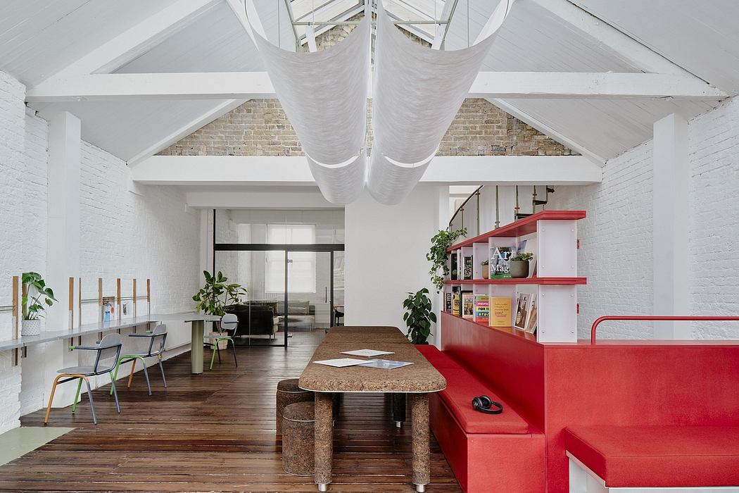 Bright, open-concept workspace with exposed brick walls, high ceilings, and modern furniture.